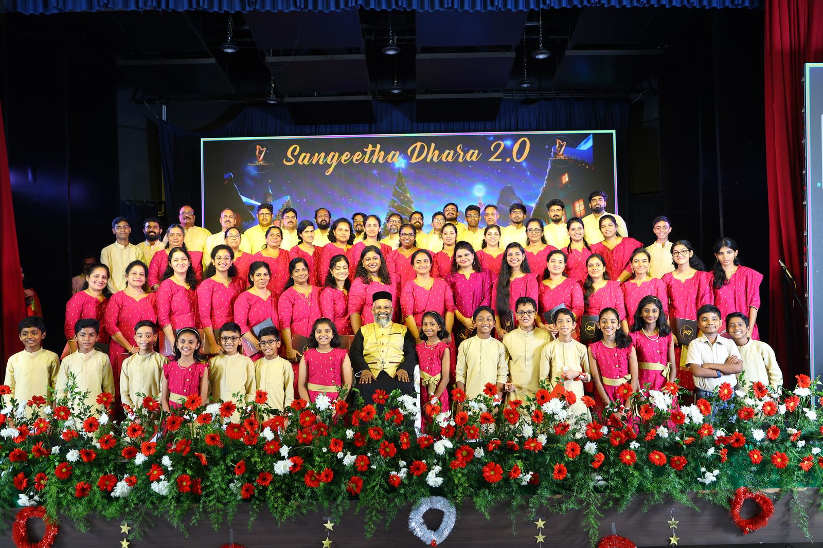 Sangeetha Dhara 2.0 — choir group photo on stage with floral decorations